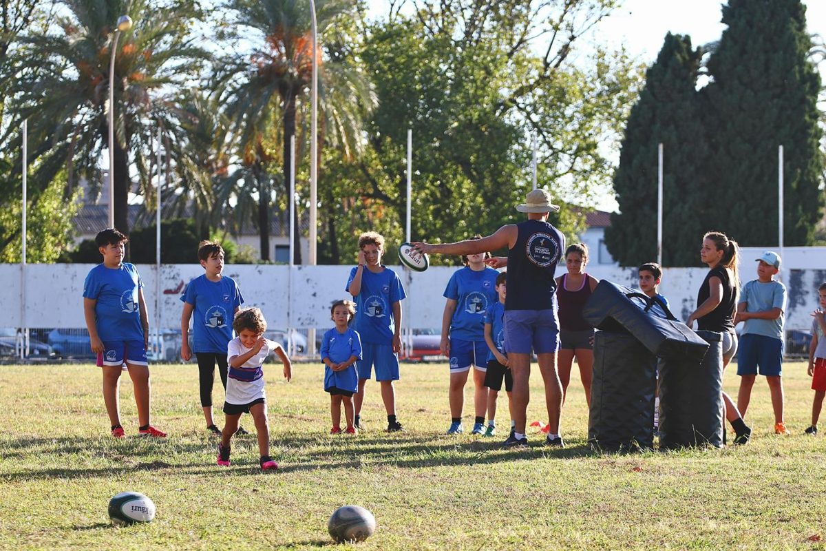 Niños y niñas de la escuela atentos a la explicación del entrenador durante un entrenamiento